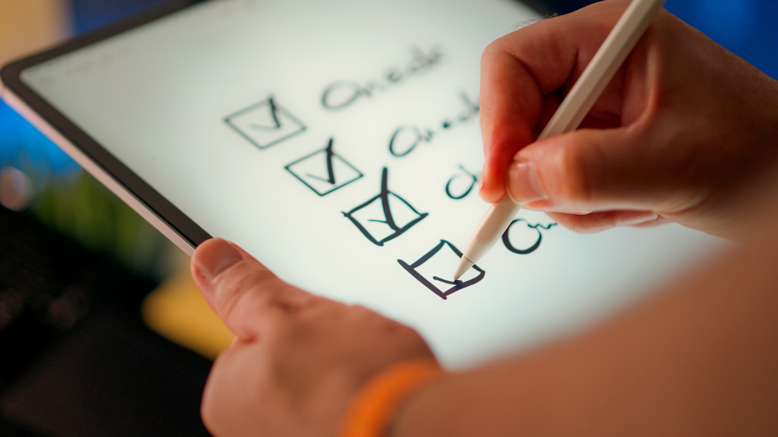 A hand using a stylus to check items off a digital checklist on a tablet, representing the day-to-day operations a vacation rental management company handles for property owners
