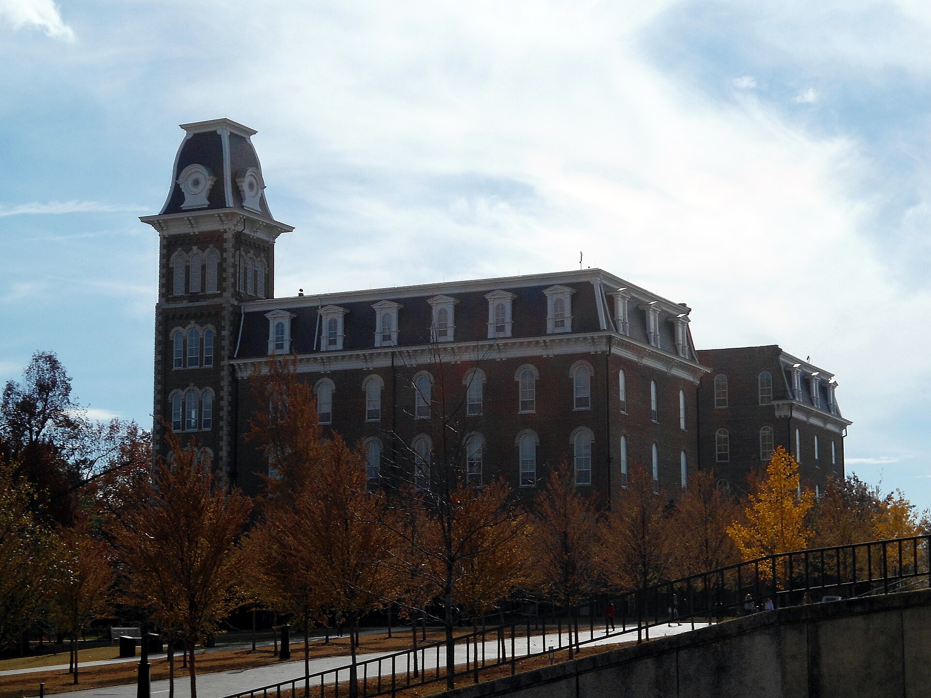 Old Main on the University of Arkansas campus in Fayetteville with autumn foliage—Airbnb and short-term rental management by Weekender Management. Photo by Brandonrush, CC BY-SA 3.0 via Wikimedia Commons.
