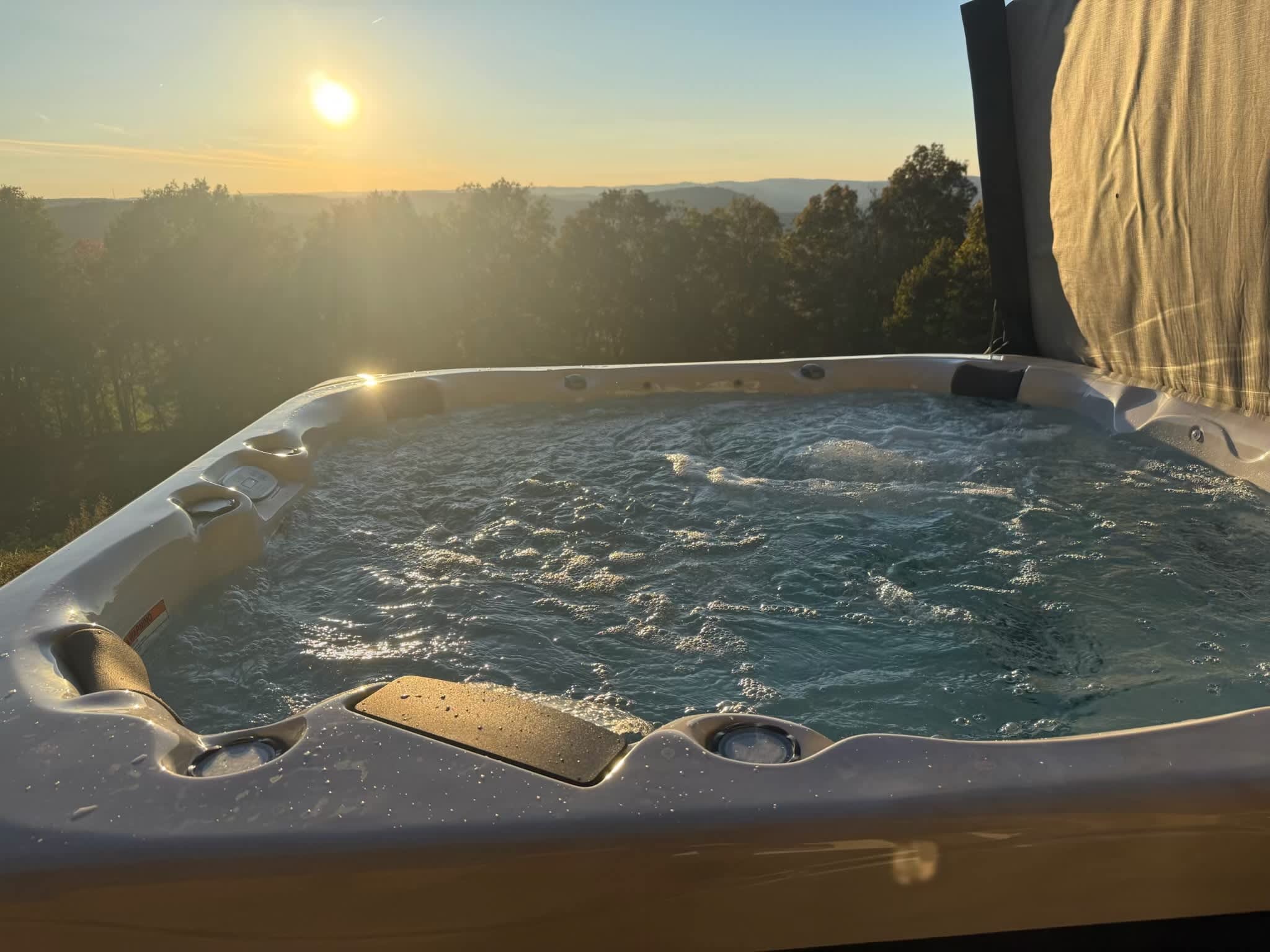 Hot tub with sunset mountain views at a Weekender-managed cabin in Newton County, Arkansas
